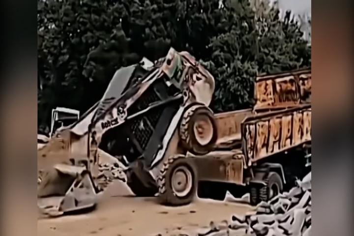 Máy xúc 'trồng cây chuối' để trèo lên xe tải